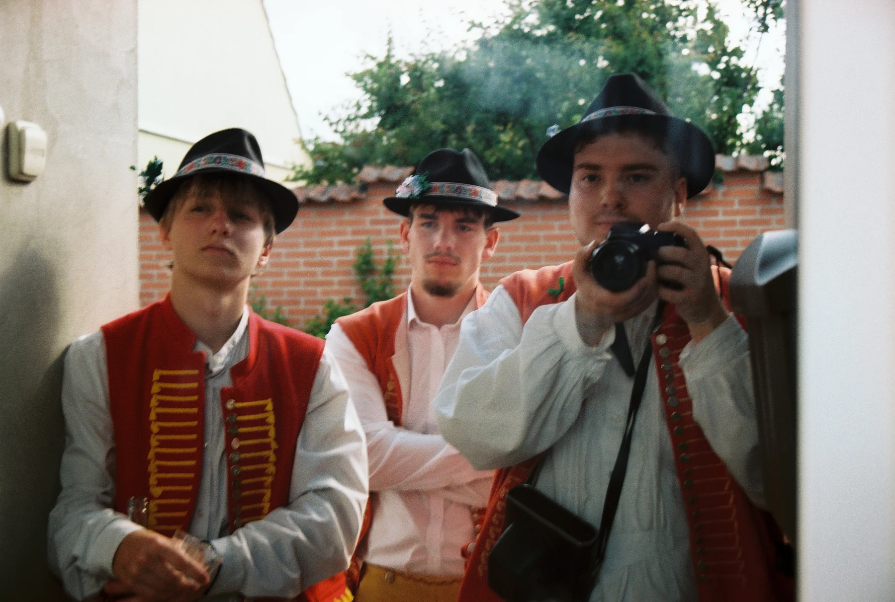 Muž fotografuje skupinu v krojích