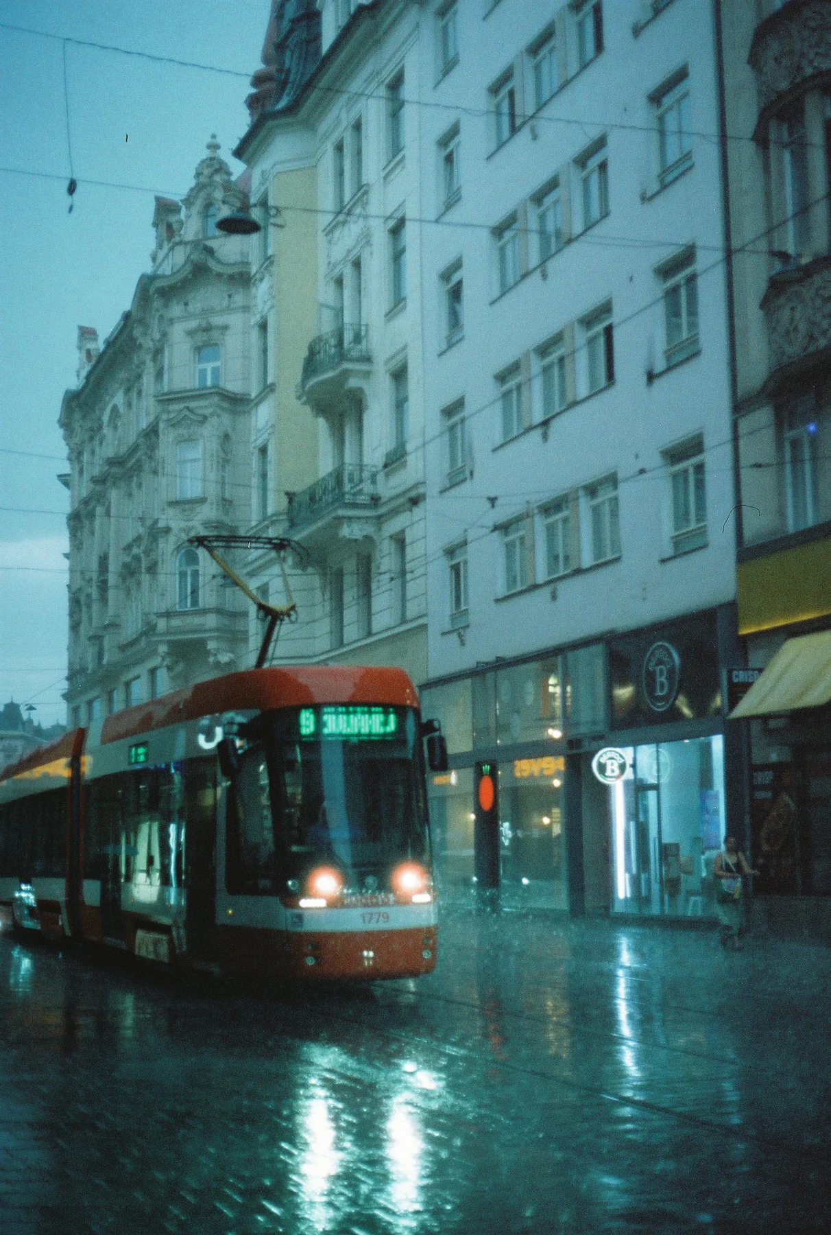 Tramvaj mezi domy v dešti