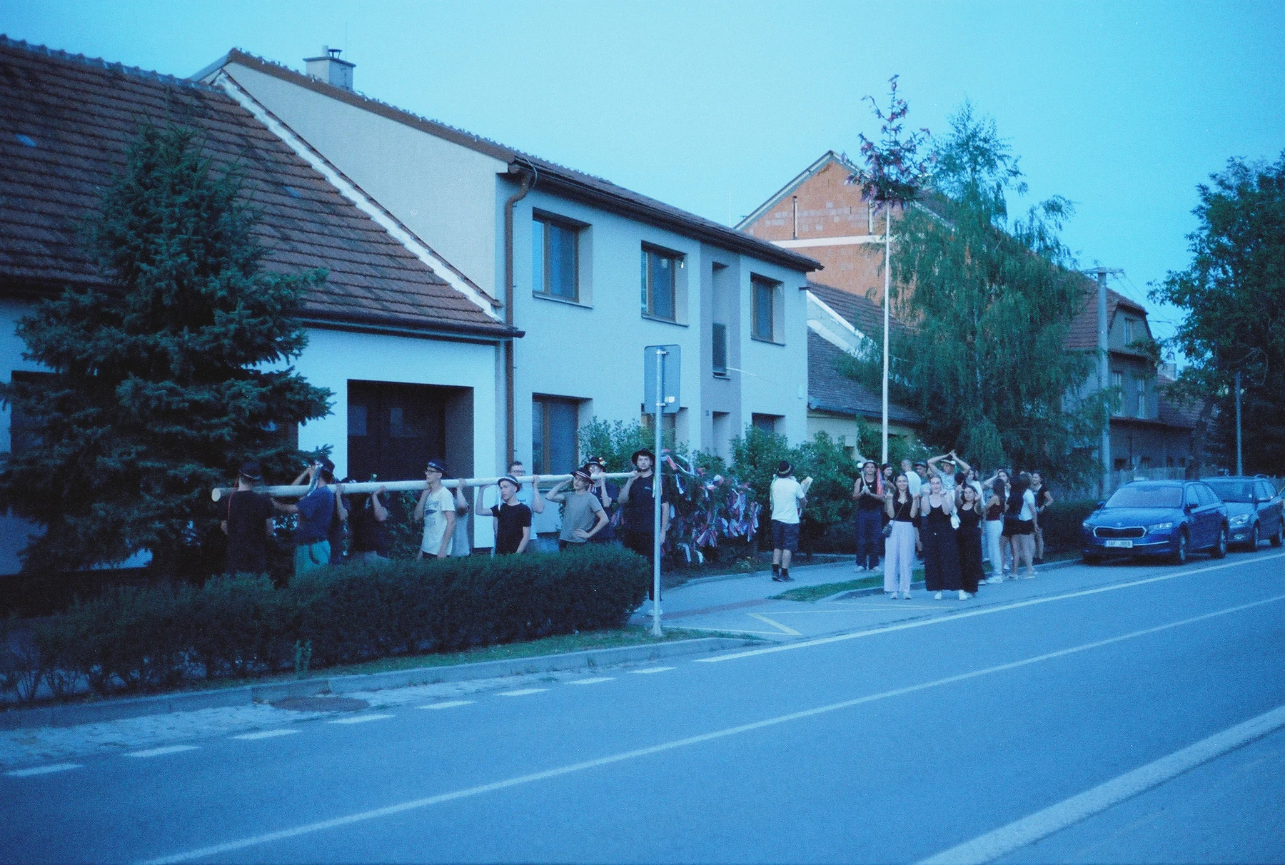 Lidé před domem u silnice
